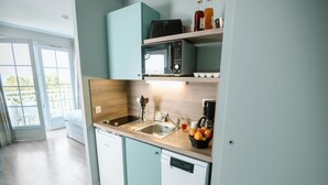 Una cocina compacta equipada con lavavajillas, microondas y cafetera.