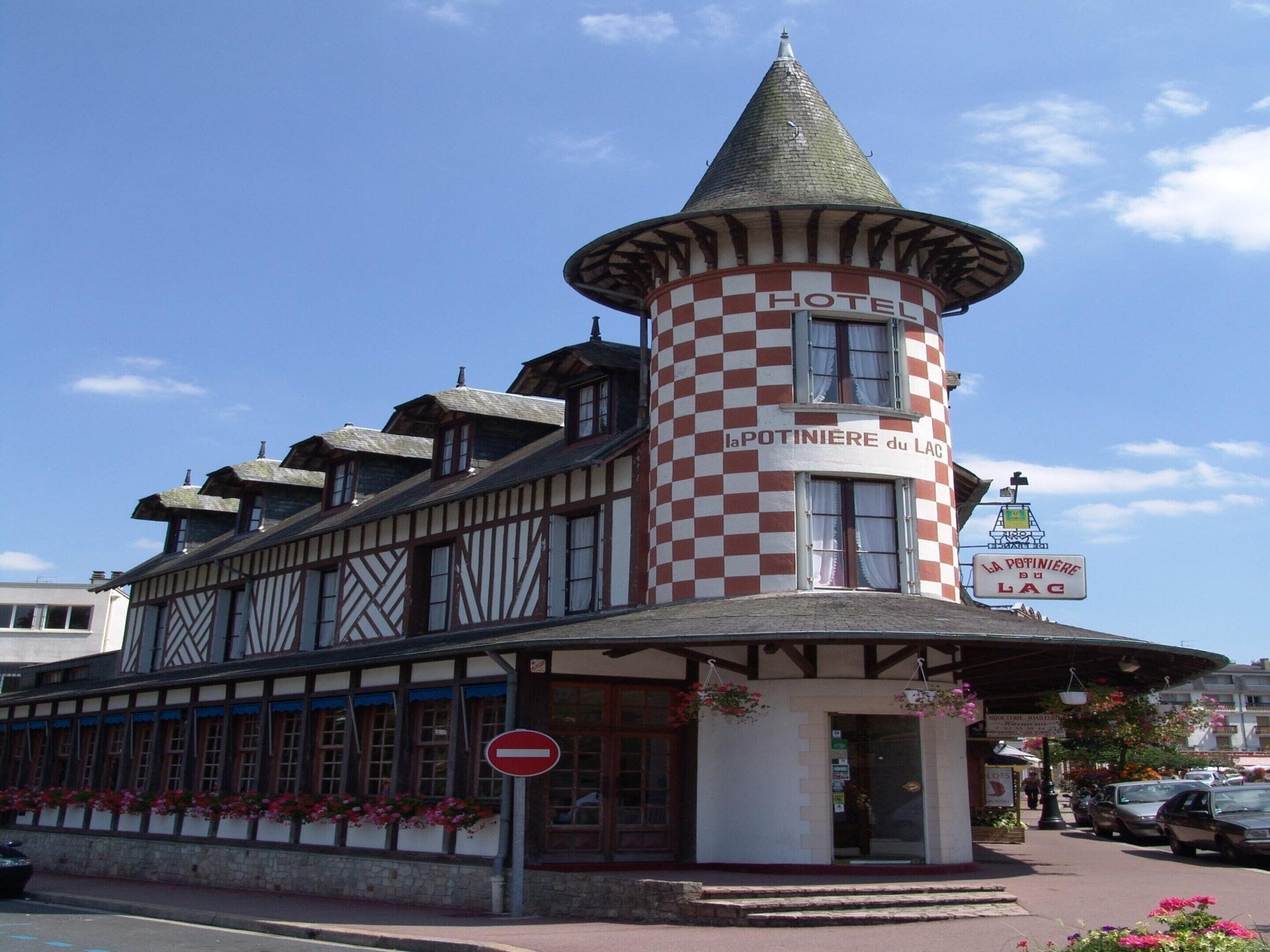 Un hotel con una torre distintiva, fachada a cuadros y un letrero que dice 'HOTEL'.