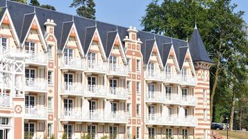 Un hotel a più piani con uno stile architettonico distintivo, caratterizzato da una torre centrale e numerosi balconi.