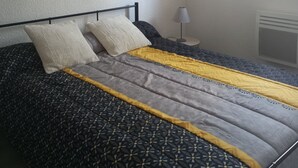 Un dormitorio con cama, un reloj de pared, una ventana y un radiador.