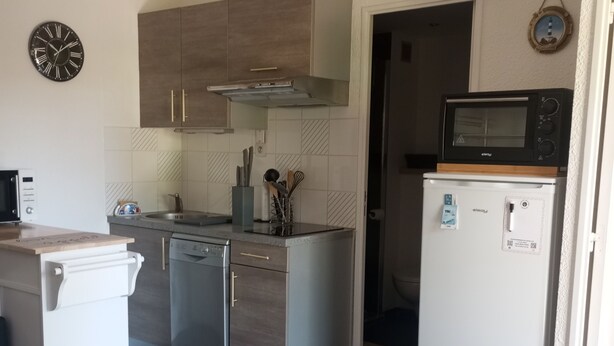 Una cocina compacta equipada con microondas, horno y lavavajillas.