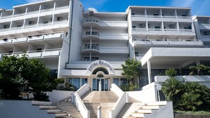 A multi-story hotel with a central entrance, balconies on each floor, and a staircase leading to the entrance. - Hotel Issa - Double Room Sea View 5 (Vis)