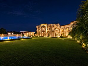 A large, multi-story building with a well-maintained lawn and a swimming pool. - Oryana Resort (Udaipur)