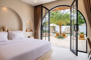 Ein Schlafzimmer mit einem großen Bett, Blick auf einen Pool und einer offenen Tür, die nach draußen führt.