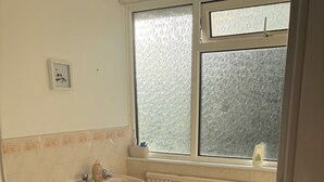 Ein Badezimmer mit Toilette, Waschbecken und Fenster.