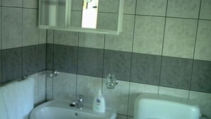 Ein Badezimmer mit Waschbecken, Spiegel und Toilette.