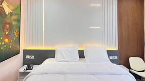Une chambre d’hôtel avec un lit, des tables de chevet, une chaise, un appareil de climatisation et un tableau au mur.