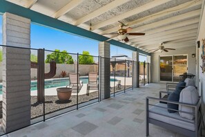 A covered patio with a pool, seating area, and ceiling fans. - Cool Off in the Pool, Family Friendly Chandler Home, Close to hiking, golf, waterpark (Chandler)