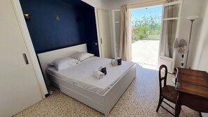 A bedroom with a bed, a chair, a desk, and a view of the outdoors. - House with pool and garden in Les Issambres (Roquebrune-sur-Argens)