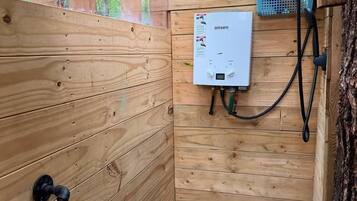 Une cabane en bois équipée d’un sauna intégré, d’un chauffe-eau et d’un panneau solaire.