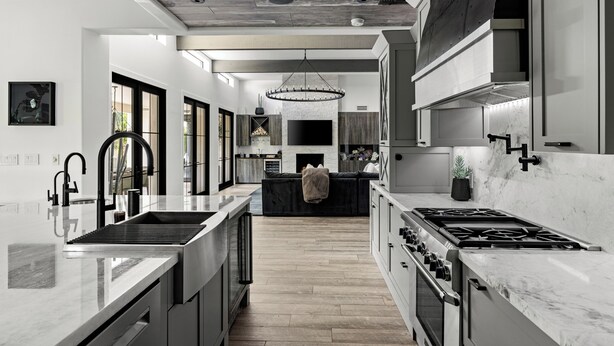 Una cocina moderna con una isla central, electrodomésticos de acero inoxidable y un ventanal grande.