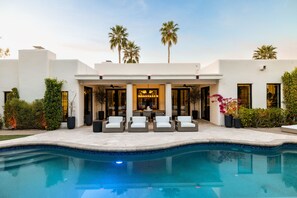A modern house with a swimming pool, outdoor seating, and palm trees. - New North Scottsdale RH Residence (Scottsdale)