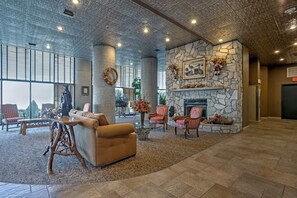 A spacious lobby with a stone fireplace, comfortable seating, and large windows. - Broken Antler at Sugar Top — Grandfather Mountain Views, Indoor Pool & Hot Tub (Sugar Mountain)