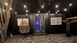 Ein modernes Haus mit Hängekorbschaukel, Glastür und Lichterkette.