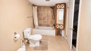 Een badkamer met toilet, bidet, douche en bad.
