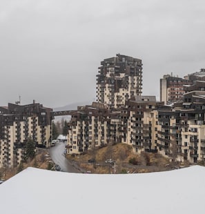 A high-rise residential building with multiple balconies and a winding road in the foreground. - 100m from ski slopes, 1st floor, view mountain, balcony, tv, 25m², Les Orres (Les Orres)