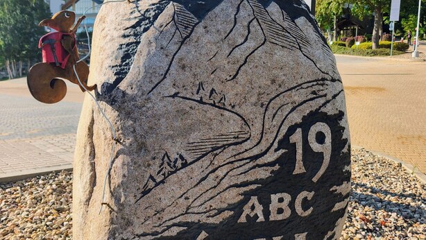 A large stone with '19 ABC GÖRNA' engraved on it, surrounded by pebbles.