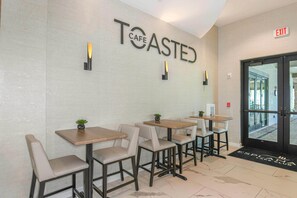 A cafe interior with a modern design, featuring tables and chairs arranged for seating. - Luxury Lakeside Resort Escape, Hidden Gem with Spectacular Views (Fort Myers)