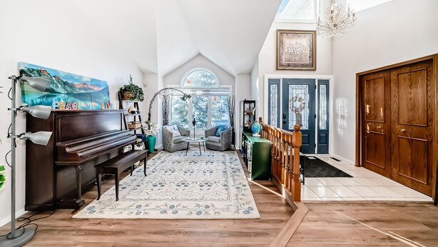 A spacious living area with a piano, a large rug, and a view of the outdoors.