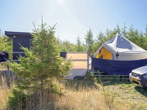 A camping site with a tent, a car, and a building. - 4 Person Holiday Home in Sejero (Sejero)