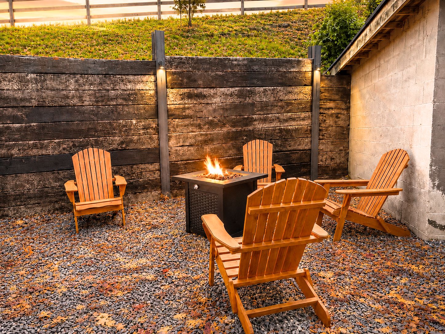 An outdoor seating area with Adirondack chairs and a fire pit.