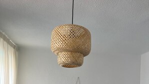 Ein Schlafzimmer mit einem Bett, einem Nachttisch, einer Lampe und einer Pendelleuchte.