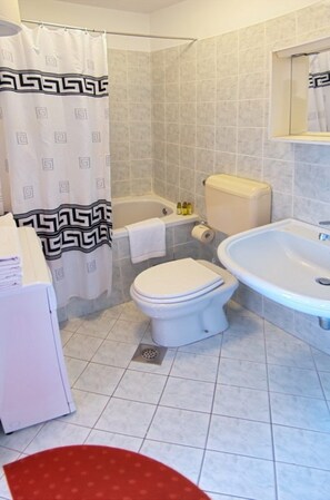 Ein Badezimmer mit Toilette, Badewanne und Waschbecken.
