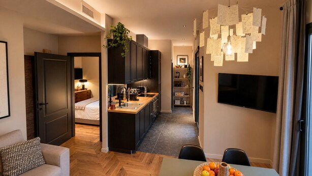 Een modern appartement met een kitchenette, een eethoek, een woonkamer en een slaapkamer.