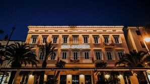 Un edificio de hotel con un letrero que dice 'HOTEL APOSTIOMEN' de noche.
