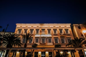 Un edificio de hotel con un letrero que dice 'HOTEL APOSTIOMEN' de noche.