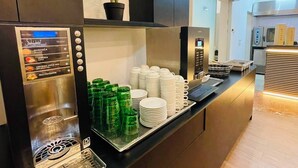 A modern kitchen with a built-in coffee machine, a potted plant, and neatly stacked plates and glasses. - Hotel APOKSIOMEN (Mali Lošinj)