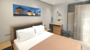 Quarto de hotel moderno com uma cama, mesas de cabeceira, cômoda, espelho e uma pintura de moinhos.