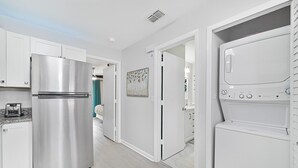 A modern kitchen with white cabinetry, a stainless steel refrigerator, and a built-in oven. - Beautiful Condo near Downtown with POOL (Cape Coral)