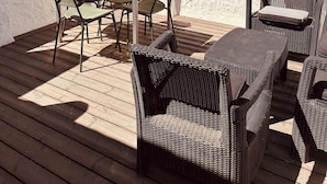 An outdoor patio with a table and chairs, surrounded by trees and a view of buildings in the background. - Penthouse in Puerto Banús (Marbella)