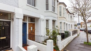 A row of white terraced houses with black and blue doors, a brick pathway, and a tree on the sidewalk. - Room-double Bedroom With own Bathroom in (London)