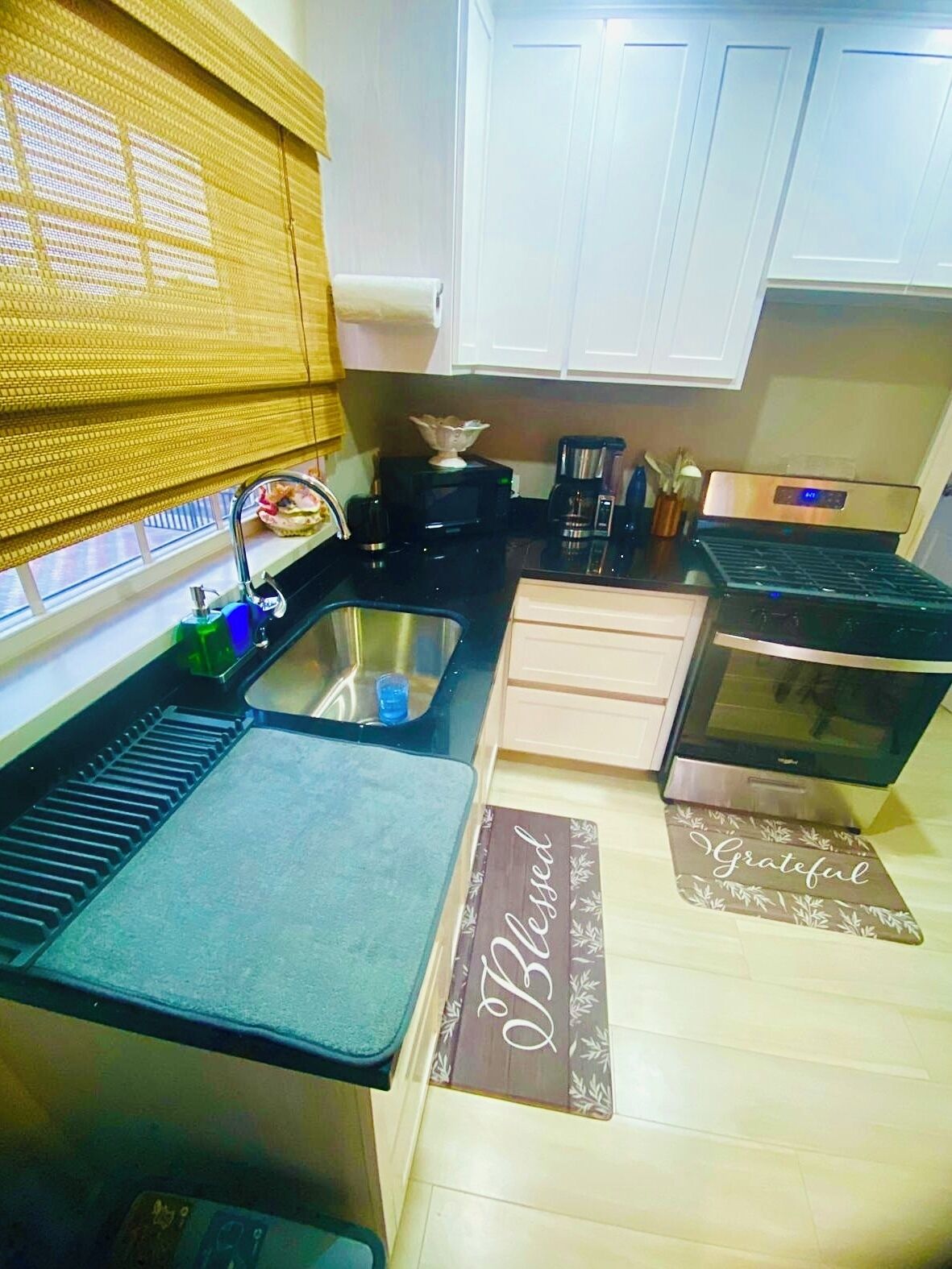 A compact kitchen with a sink, stove, and cabinets.