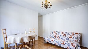 A dining area with a table, chairs, and a sofa. - L'Écrin Thermal - Appt avec balcon et vue dégagée (Amélie-les-Bains-Palalda)