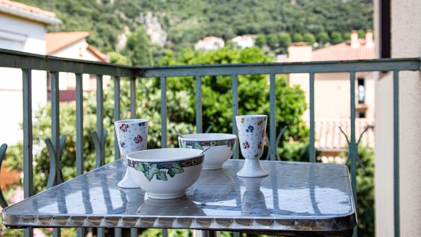 A balcony with a metal table, three bowls, and a cup. - L'Écrin Thermal - Appt avec balcon et vue dégagée (Amélie-les-Bains-Palalda)
