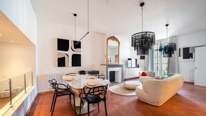 Uma sala de estar moderna com área de jantar, lareira e um espelho grande.