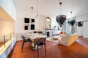 Ein modernes Wohnzimmer mit Essbereich, Kamin und einem großen Spiegel.