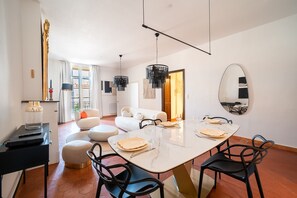 Ein moderner Essbereich mit einem weißen Tisch, schwarzen Stühlen und einem großen Spiegel an der Wand.