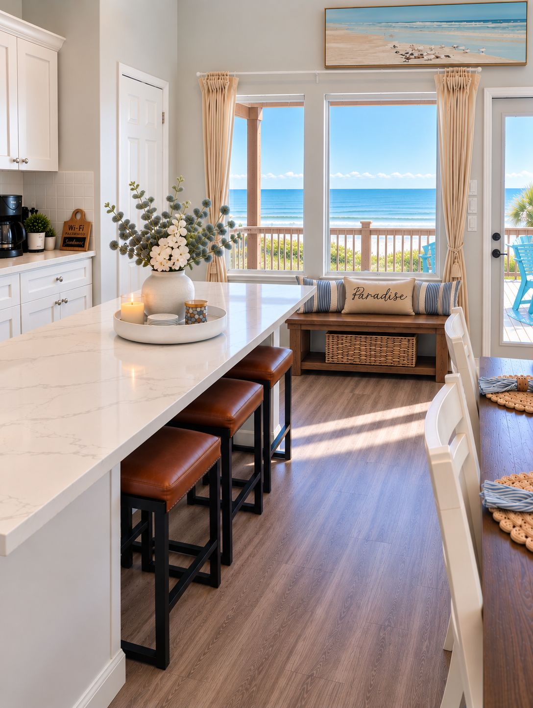 A kitchen with a large island, wooden stools, a view of the ocean, and a sign indicating Wi-Fi availability.