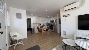 Um apartamento moderno com sala de jantar, cozinha e sala de estar.