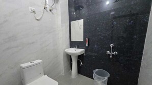 A bathroom with a toilet, sink, and shower. - Deluxe Lexa Grand (Lucknow)