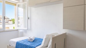 Un dormitorio con cama, ventana y armario.