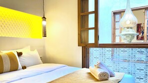 Ein Hotelzimmer mit Bett, einem Fenster mit Blick und einer Hängelampe.