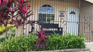 Un edificio con fachada curva, una reja metálica y un banco.