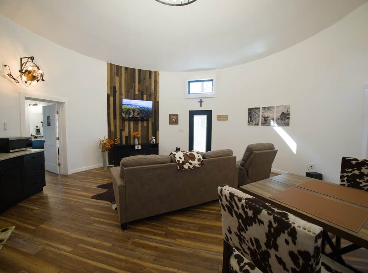 Una sala de estar moderna con un sofá, una mesa de centro y un televisor montado en la pared.