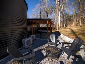 Un espacio al aire libre con patio, una chimenea, asientos y una estructura cubierta.