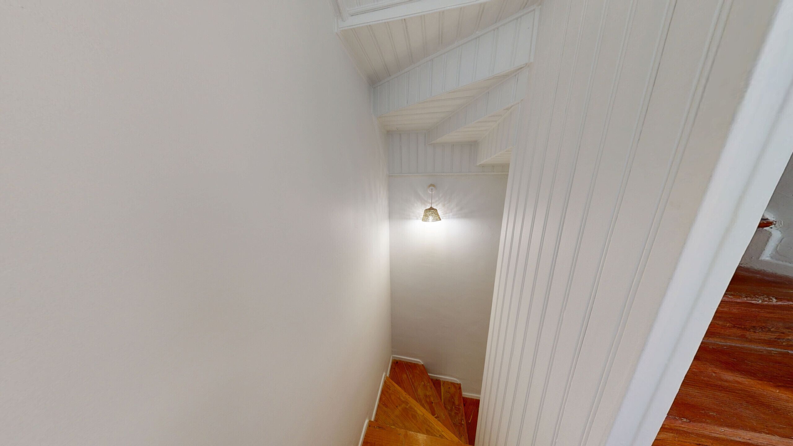 A staircase with wooden steps leading to a landing with a light fixture.